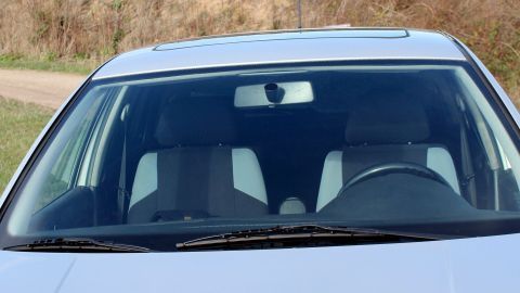 Eingefrorene Autoscheiben zeigen virale Glätte, während das Auto in einer natürlichen Umgebung parkt.