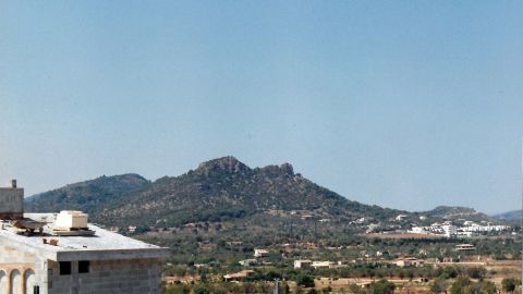 Eine Berglandschaft erhebt sich majestätisch im Hintergrund, während ein klarer blauer Himmel über Spanien strahlt.