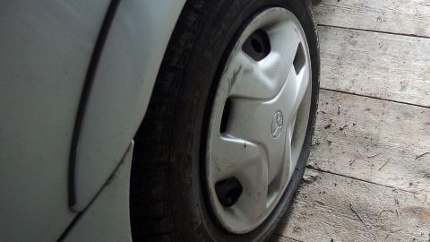 Ein festgerostetes Rad liegt auf einem Holzboden und erfordert spezielle Techniken zur Lösung ohne Hebebühne.