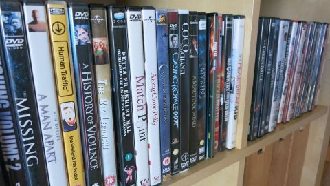 Eine Auswahl an DVDs steht auf einem Regal, während die Debatte über den Verkauf von FSK 18-Inhalten auf Ebay anhält.