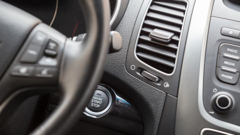 In einem Auto sieht man das Lenkrad und die Bedienelemente. Kunststoffteile glänzen, gut gepflegt mit Vaseline.