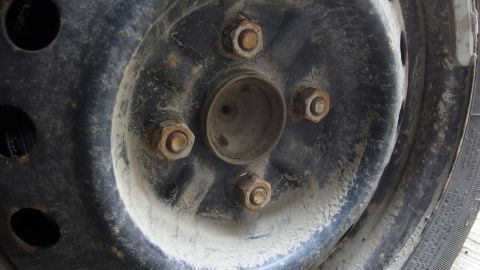 Festrosten von Rädern verhindern - Nabe mit Silikonspray besprühen - ein Tipp aus der Motorbootszene. Ein rostiger Auto-Reifen mit festgerosteten Schrauben, der Schwierigkeiten beim Reifenwechsel verursacht.