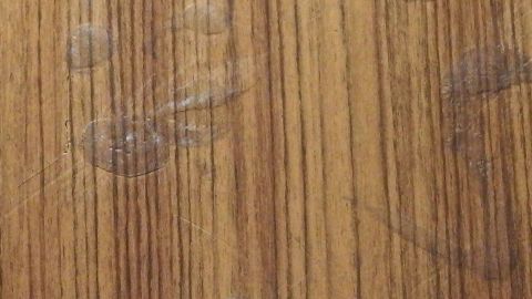 Klebestreifen auf Stufen: Mit der Heißluftpistole habe ich die Stellen kurz stark erhitzt und dann ließ sich der Klebestreifen mühelos entfernen. Holzstufen mit Kleberesten sind sichtbar, die die Holzmaserung teilweise verdecken und unschön wirken.