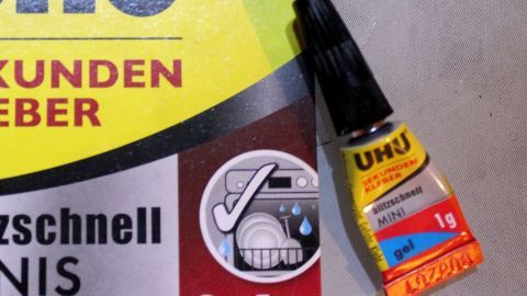 Wen wundert es, Sekundenkleber klebt in Sekunden. Oftmals an den Fingern. Dann heißt es schnell handeln, um diesen dort wieder abzubekommen. Hier hilft Gallseife und der Kleber ist schnell weg. Ein Tubenfläschchen mit Sekundenkleber liegt neben dem Hinweis zur Reinigung mit Gallseife auf einem gelben Hintergrund.