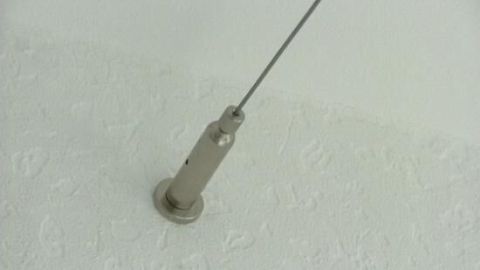 Ein Duschvorhangring ist an einem befestigten Wandhalter installiert, um einen Duschvorhang über Eck aufzuhängen.