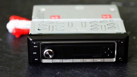 Ein Autoradio liegt auf einem Tisch, bereit zum Ausbau ohne Demontage-Werkzeug, in einer lässigen, neutralen Umgebung.