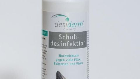 Eine Flasche Schuhdesinfektionsspray steht auf einem hellen Hintergrund und bietet eine Lösung gegen stinkende Füße.