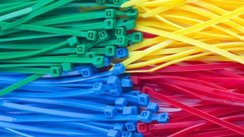 Bunte Kabelbinder liegen ordentlich gestapelt, bereit zum Lösen und Wiederverwenden in verschiedenen Projekten.