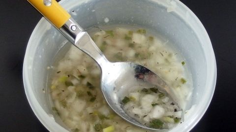 Ein Behälter mit Dip, darin ein Löffel, der kräftige Aromen in einer cremigen Mischung zeigt, ideal zum Genießen.