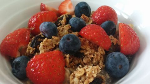 Eine Schüssel mit Chia-Samen bietet frische Erdbeeren und Heidelbeeren, umgeben von einer warmen, einladenden Atmosphäre.