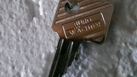 Ein Schlüssel liegt auf einer rauen Wand, symbolisiert einer möglichen Lösung, wenn man den Schlüssel vergessen hat.