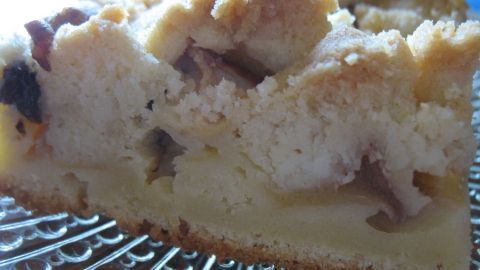Saftiger Apfelkuchen mit goldbraunen Butterstreuseln liegt auf einem Kuchengitter und strahlt Frische und Genuss aus.