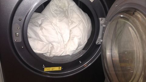 Saubere, weiche Wäsche befindet sich im offenen Trockner, bereit zum Herausnehmen für frischen Duft und Komfort.