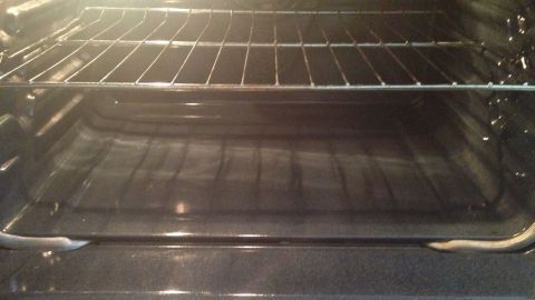 Ein sauberer Backofen zeigt leere Roste und eine glatte Fläche, bereit zum Backen von Pflaumenkuchen in der Küche.