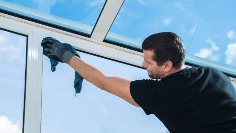 Mann putzt Fenster