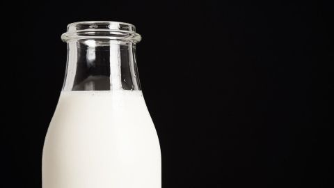 Ein Glas frisch homogenisierte Milch steht auf einem dunklen Hintergrund, perfekt für die Diskussion über Milchunverträglichkeit.
