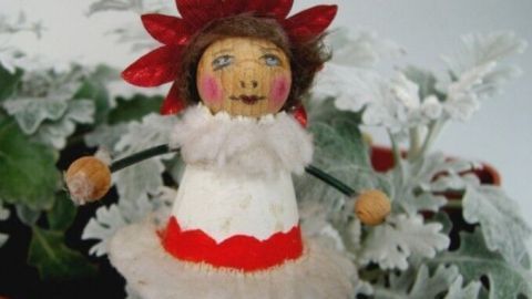 Eine Tontopf-Elfe aus einem Tontöpfchen tanzt vor einer blühenden Pflanze und bringt festliche Dekoration ins Zimmer.