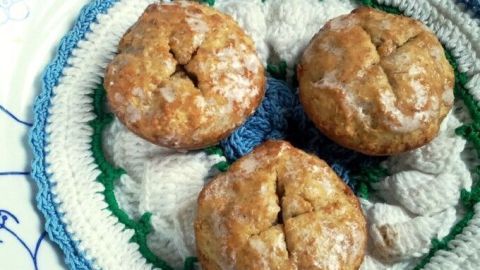Drei goldbraune Hirse-Müsli-Plätzchen liegen auf einem bunten, gehäkelten Teller und wirken frisch gebacken.