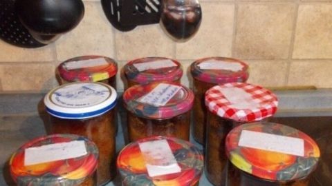 In mehreren Gläsern befindet sich selbstgebackener Kirschkuchen, ordentlich verpackt und in einer Küche aufgestellt.
