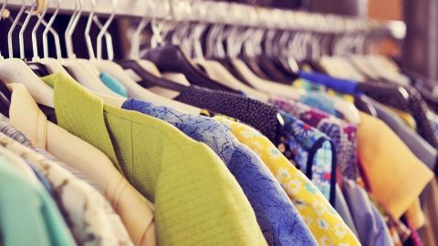 Bunte Kleidung hängt ordentlich auf Kleiderbügeln in einem Geschäft, bereit zum Verkauf im Internet.