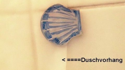 Eine selbstklebende Klemme hält den Duschvorhang an Ort und Stelle, während sie an einer Wand befestigt ist.