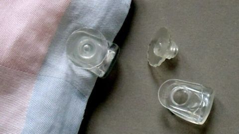 Eine transparente Befestigung für Bettdecken liegt neben einem Bezug, der frisch aufgezogen ist, um Verrutschen zu verhindern.