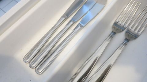 In einer weißen Besteckschublade liegen ordentliche Edelstahl-Messer und -Gabeln, kein Anlaufen sichtbar.