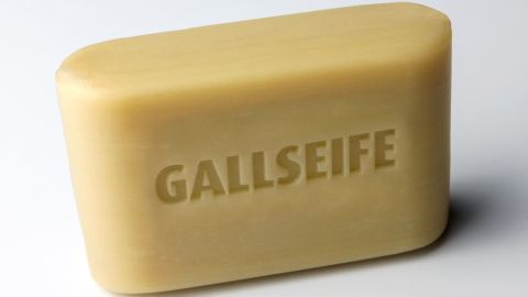 Ein Stück Gallseife liegt auf einer neutralen Oberfläche und zeigt deutlich die eingestempelte Schrift "GALLSEIFE".