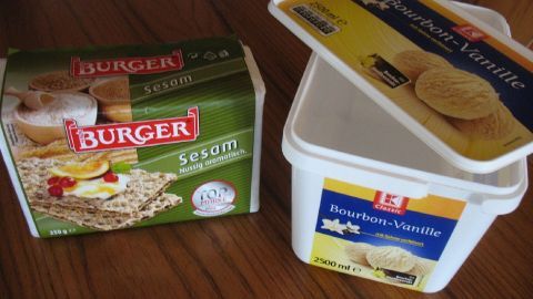 Knäckebrot liegt neben einem Behälter für Butter, beide auf einem Holztisch, bereit zur Verwendung.