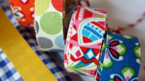 Bunte Washi Tape-Rollen liegen auf einem karierten Untergrund, um DIY-Projekte kreativ zu gestalten.