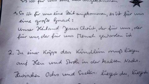 Ein handgeschriebenes Blatt zeigt den Text des Weihnachtsliedes, das zur festlichen Saison und besinnlichem Feiern einlädt.