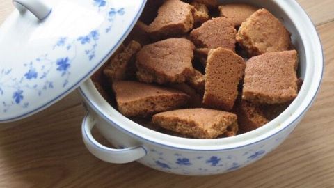 Ein gefüllter Topf mit Honiglebkuchen-Bruch steht auf einem Holztisch, bereit zum Servieren und Genießen.