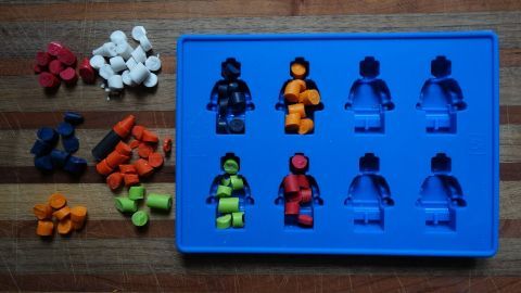 Bunte Wachsmalstifte sind in der Form eines blauen Silikonschalenmusters angeordnet, um kreative Figuren zu schaffen.
