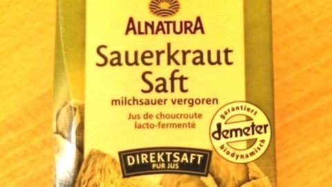 Eine Verpackung von Sauerkrautsaft steht auf einem Holztisch. Der Saft soll eine milchsaure Vergärung fördern.