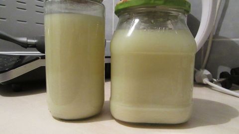 Zwei Gläser mit einer milchigen Flüssigkeit stehen auf einem Tisch in einer modernen Küche. Bluthochdruck natürlich senken.