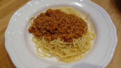 Ein Teller Spaghetti mit einer herzhaften Gemüse-Soße ist appetitlich angerichtet und bietet eine kinderfreundliche Gemüseoption.