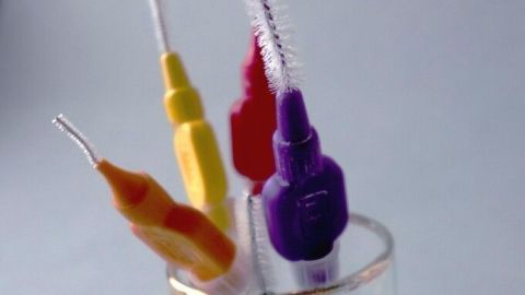 Bunte Interdentalbürsten stehen in einem Glas und sind bereit, Zahnzwischenräume besser zu reinigen.
