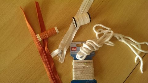 Bunte Nähutensilien liegen auf einem Tisch, geordnet nach Farbe und bereit zum Kauf für kreative Projekte.