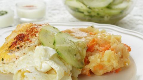 Ein leckerer Diätessen-Teller zeigt eine Portion mit Gemüse, umgeben von einem erfrischenden Gurkensalat.