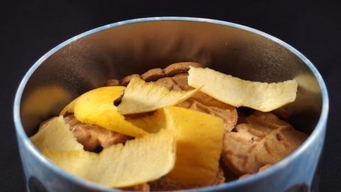 Apfelschalen oder Kartoffelschalen geben den Plätzchen etwas Feuchtigkeit zurück. Harte Plätzchen in einer runden Dose werden von orangefarbener Schale umgeben, die frisch und appetitlich aussieht.