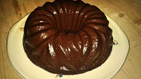 Ein saftiger Nuss-Schoko-Kuchen liegt auf einem weißen Teller und verströmt einen köstlichen Duft in einer gemütlichen Küche.