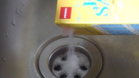Salz wird aus einer gelben Packung in ein Spülbecken gegossen, um unangenehme Gerüche zu bekämpfen.