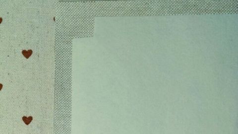 Vlieseline mit braunen Herzen wird auf einer Fläche geformt, um Ecken zu verstärken und stabilisieren.