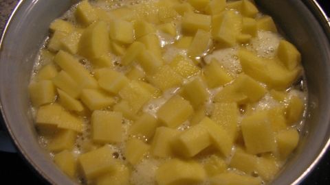 Würfelförmige Kartoffeln kochen in einem Topf mit leicht sprudelndem Wasser, bereit für das beste Kartoffelpüree.