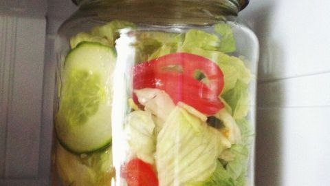Reste von Salat in einem verschlossenen Schraubglas im Kühlschrank länger frischhalten. Ein Glas mit frischem Salat, das im Kühlschrank steht, bewahrt die Zutaten sicher und frisch auf.