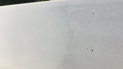 Eine Aluminiumfensterbank zeigt reinigende Aktionen, während sie im Freien auf einem gepflasterten Boden liegt.