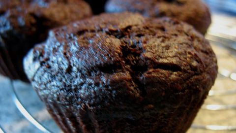Saftige Schoko-Bananen-Muffins mit glänzender Oberfläche ruhen auf einem Kühlgitter, bereit zum Verzehr.