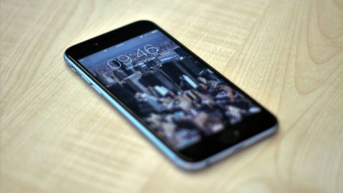Ein Smartphone liegt auf einem Tisch. Der Lockscreen zeigt eine städtische Landschaft, bereit zum Kontaktzugriff.