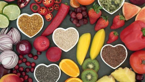 Bunte Lebensmittel und gesunde Inhaltsstoffe sind kreativ in Herzschalen arrangiert, um fleischlose Ernährung zu fördern.