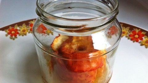 Ein Bratapfel im Glas wird präsentiert, liegt auf einem bunten Teller und strahlt süßes, fruchtiges Aroma aus.